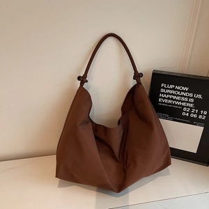 Braune Nylon-Hobo-Tasche mit Knotengriff-Design auf einer weißen Marmoroberfläche