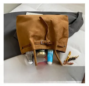 Detailansicht der großen Innenkapazität dieser braunen Wildleder-Tote-Bag mit Alltagsgegenständen