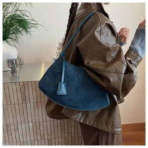 Détail du sac à bandoulière en daim bleu marine avec un design asymétrique en éventail