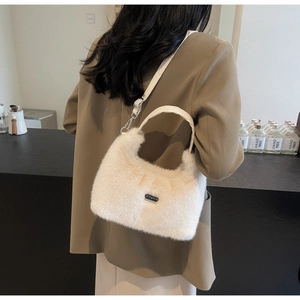 Detail of white faux fox fur handbag with moon shape and leather shoulder strap