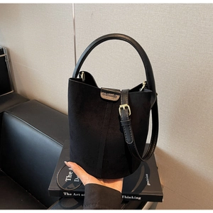 Detail shot of the matte black bucket bag showing the vertical stitching and Daxi & Bag logo