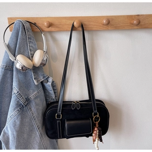 Detail of black Boston bag featuring white contrast stitching and vintage beaded charm