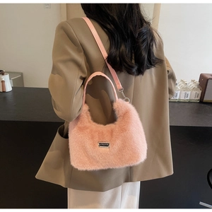 Detail shot of the pink faux fur handbag showing high-quality plush texture and metal logo