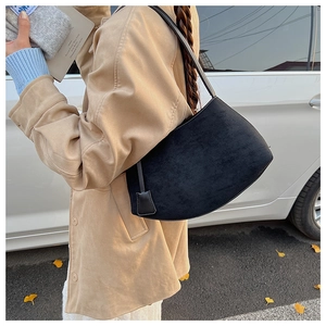 Détail du sac bandoulière en daim noir avec pendentif carré et bandoulière fine