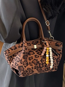 Modische Handtasche mit Leopardenmuster, Lederbesatz und dekorativem Perlenanhänger
