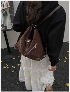 Detail of dark brown leopard embossed backpack with functional zippers on autumn street
