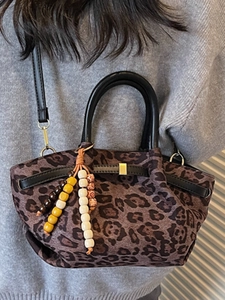 Modische Handtasche mit Leopardenmuster, Ledergriffen und buntem Perlenanhänger-Detail