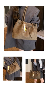 Detail der braunen Vintage-Wildleder-Einkaufstasche mit Lederschnalle und Perlenanhänger