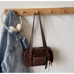 Detail of vintage brown suede shoulder bag with dual straps and decorative wood beads