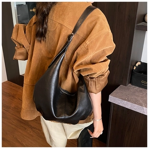 Detailed view of large black leather hobo bag showing adjustable silver buckle and texture