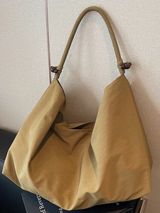 Schicke senfgelbe Hobo-Tasche mit Holzperlen-Details und strukturiertem Stoff