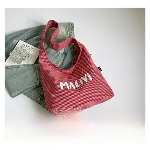 Detail of red and white gingham canvas tote bag featuring white MALIVI text print