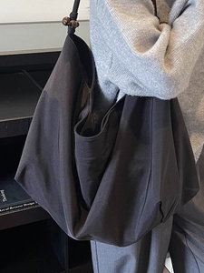 Minimalistische schwarze Segeltuchtasche mit Holzperlen für die herbstliche Reisemode