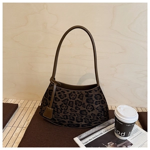 Gros plan du sac porté épaule léopard avec une texture rétro et un design courbé