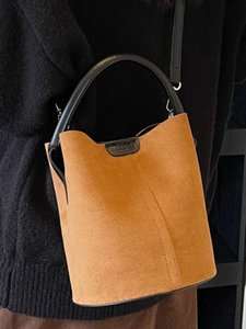 Brown matte suede bucket bag with black leather handle for casual fashion look