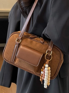 Retro caramel suede Boston bag with wooden bead charm and sleek shoulder strap