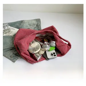 Detail of red gingham canvas tote bag interior showing large capacity for daily items