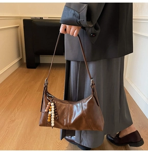 Gros plan d'un sac sous les bras vintage marron avec perles en bois et texture cuir