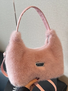 Chic pink faux fur crossbody bag with soft plush texture and adjustable leather strap