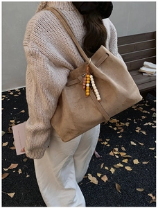 Detail der khakifarbenen Wildledertasche mit böhmischem Holzperlen-Anhänger-Dekor