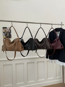 Detailed row of tote bags in four colors showing leather texture and adjustable strap