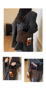 Detailed views of brown leather bucket bag with fashion logo and bear charm on model