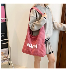 Close-up of red and white checkered canvas tote bag with MACVI lettering and fabric label