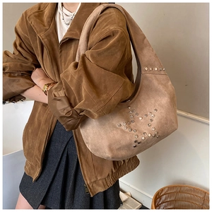 Detalle del diseño de estrella con remaches en el bolso hobo de ante marrón para mujer