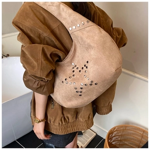 Detail of camel suede tote bag with metallic star studs and bohemian aesthetic design