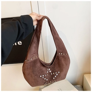Detalle de remaches plateados en forma de estrella en bolso hobo de ante marrón