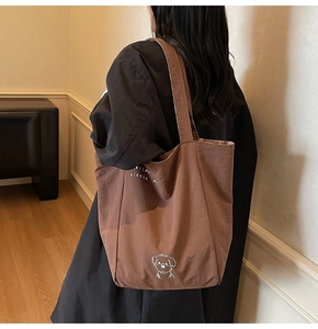 Detailed view of brown canvas tote bag featuring a cute white puppy embroidery design