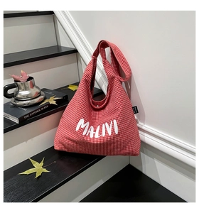 Detail of red and white checkered canvas tote bag with MALIVI letter print on stairs