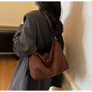 Dettaglio della borsa hobo in pelle scamosciata marrone caffè con fibbie dorate lucide