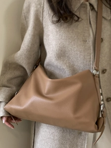 Caramel lychee grain leather crossbody tote bag shown on model in a soft autumn outfit