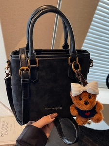 Retro black suede tote bag with a brown bear pendant and adjustable shoulder strap