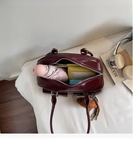 Top view of spacious burgundy boston bag showing interior storage for wallet and umbrella