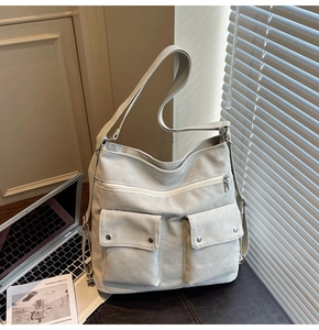 Detailed macro view showing canvas texture and two functional front pockets on the tote bag