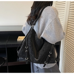 Detail of black suede tote bag featuring silver buckle strap and large capacity