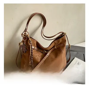 Close-up of leopard embossed texture and bear charm detail on vintage brown tote bag