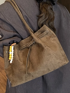 Vintage braune Wildleder-Einkaufstasche mit Zierriemen und Holzperlenanhänger auf der Schulter