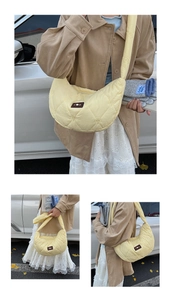 Detail of yellow quilted dumpling bag with heart stitching and logo patch