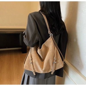 Model wearing khaki suede tote bag showcasing large capacity and adjustable buckle details