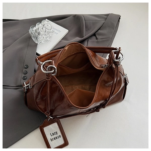 Detailed interior of brown leather tote showing inner pockets and silver ring hardware