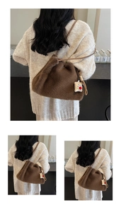 Dettaglio della borsa tote in peluche marrone con texture morbida e ciondolo orso