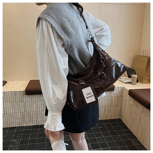 Detailed shot of dark coffee glossy leather shoulder bag with side zipper pocket