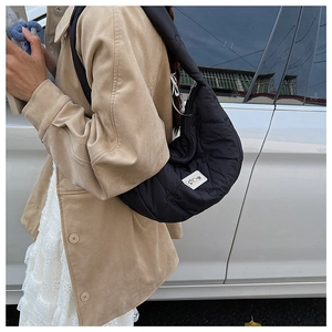 Detail der schwarzen gesteppten Hobo-Tasche mit Herzmuster und breitem Schultergurt