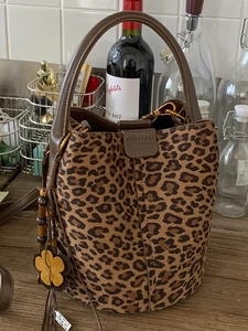 Retro leopard print suede bucket bag with brown leather handles and bohemian flower charm