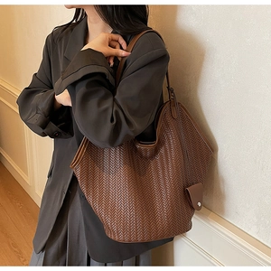 Détail de la texture tressée et du design vintage marron foncé de ce grand sac cabas