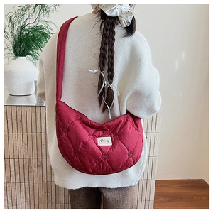 Detailansicht der tiefroten Umhängetasche mit Herzsteppung und weicher Puffer-Textur