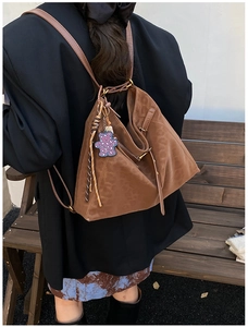 Detailed back view of a large vintage brown leather backpack with leopard bear charm